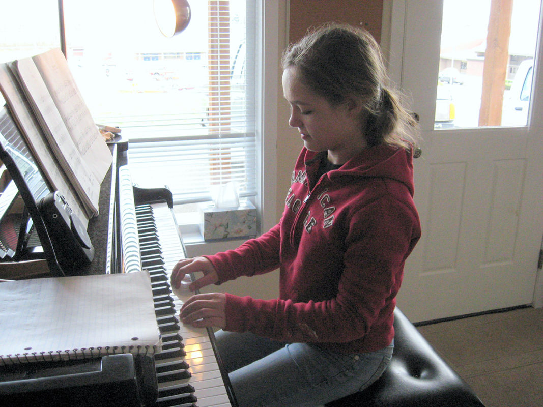 Photo of a young girl playing piano.