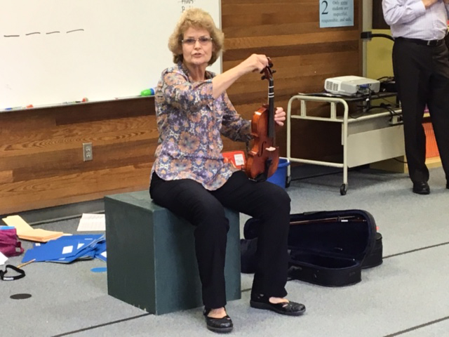 Photo of an instructor seated with a violin.