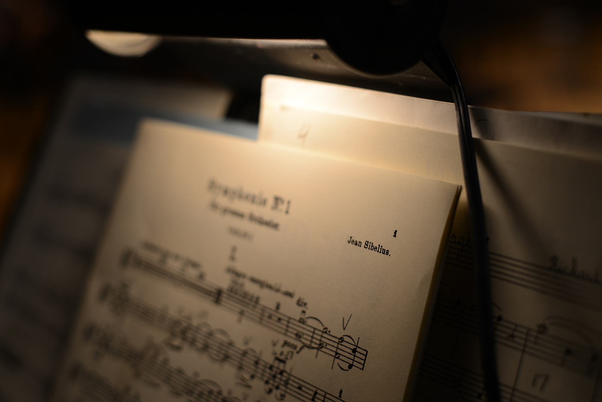 Moody photo of sheet music with an overhead light.