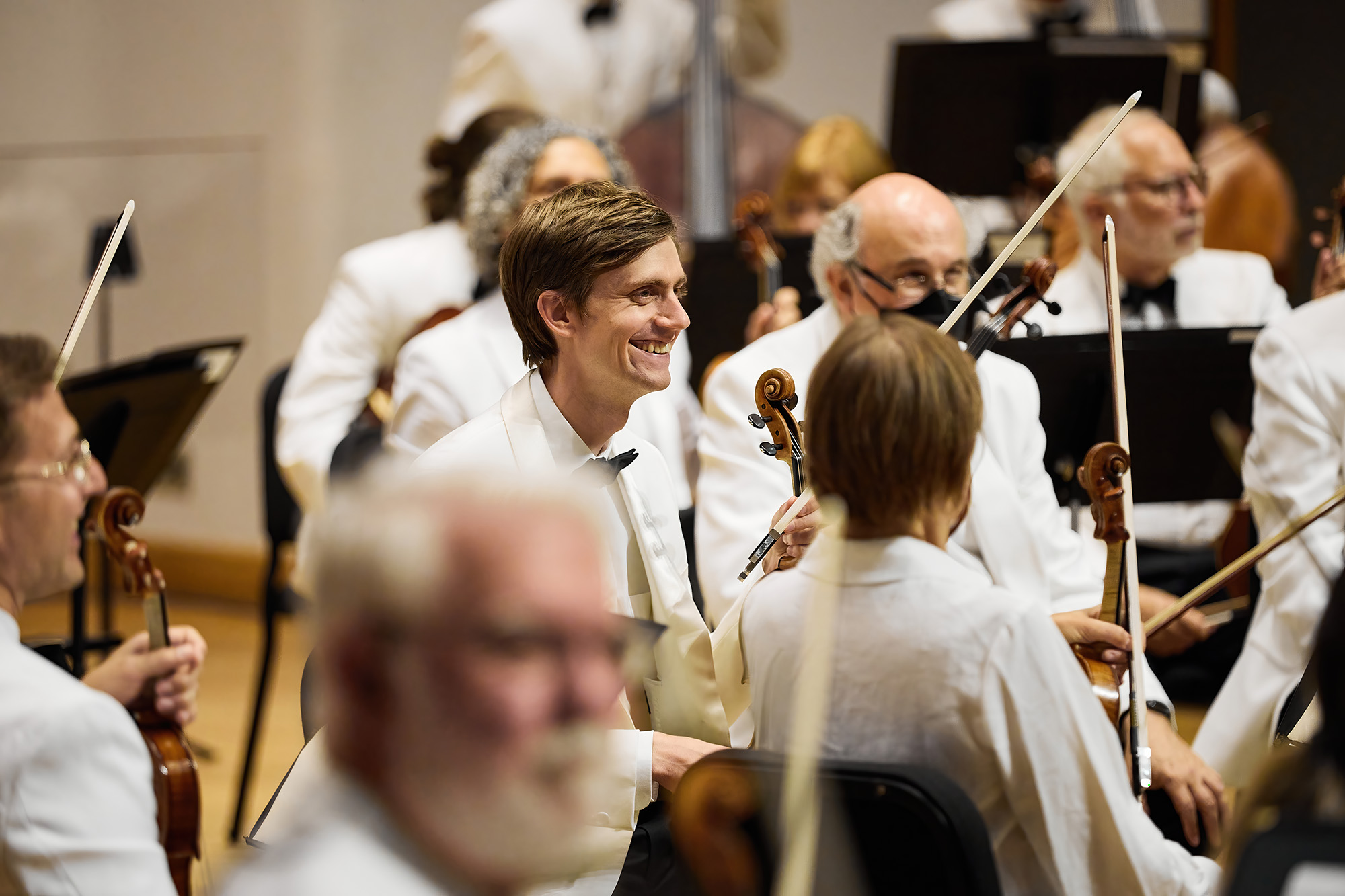 Photo of an orchestra member smiling.