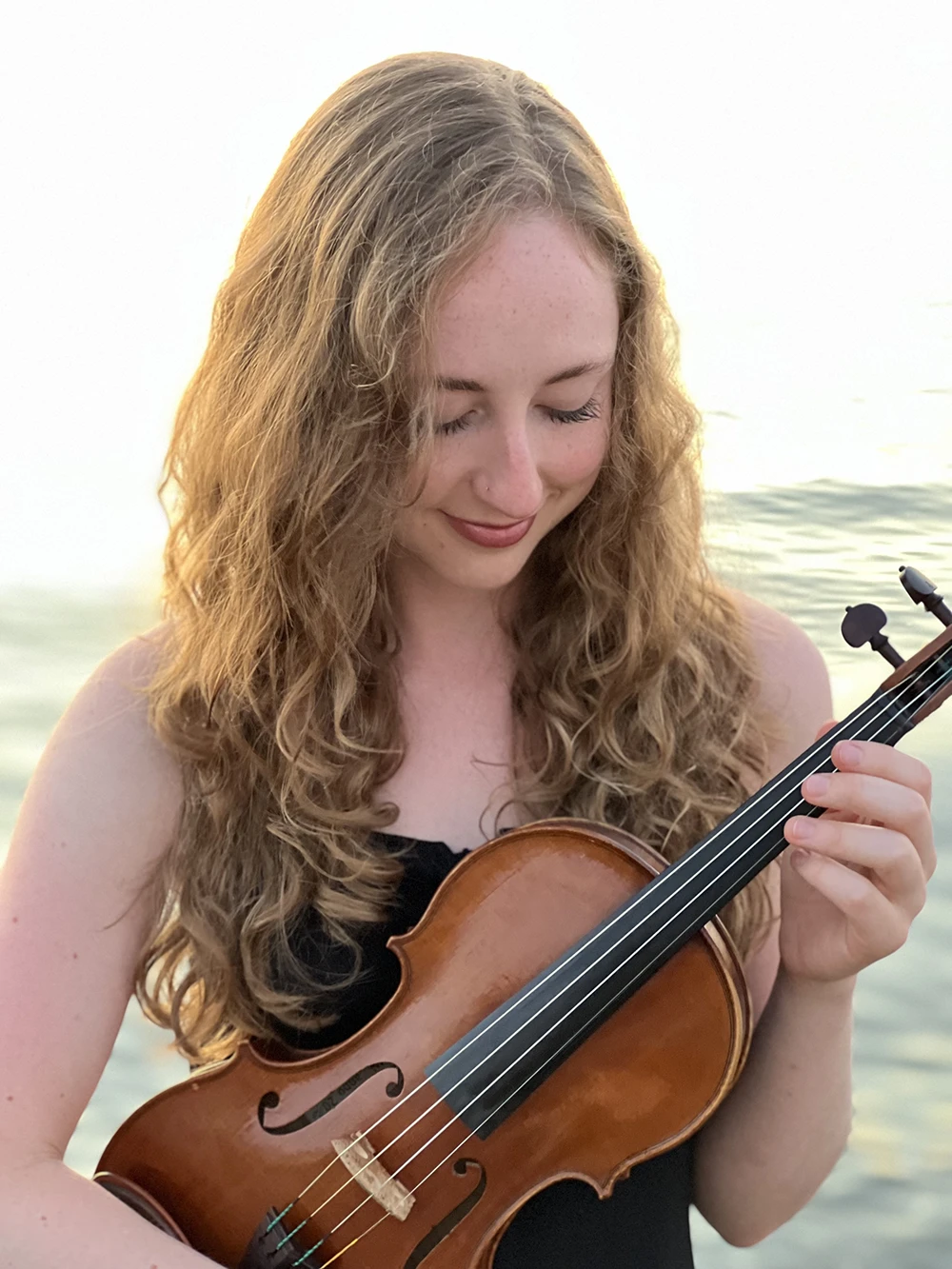 Photo of violinist, Hannie McGarity holding her violin.