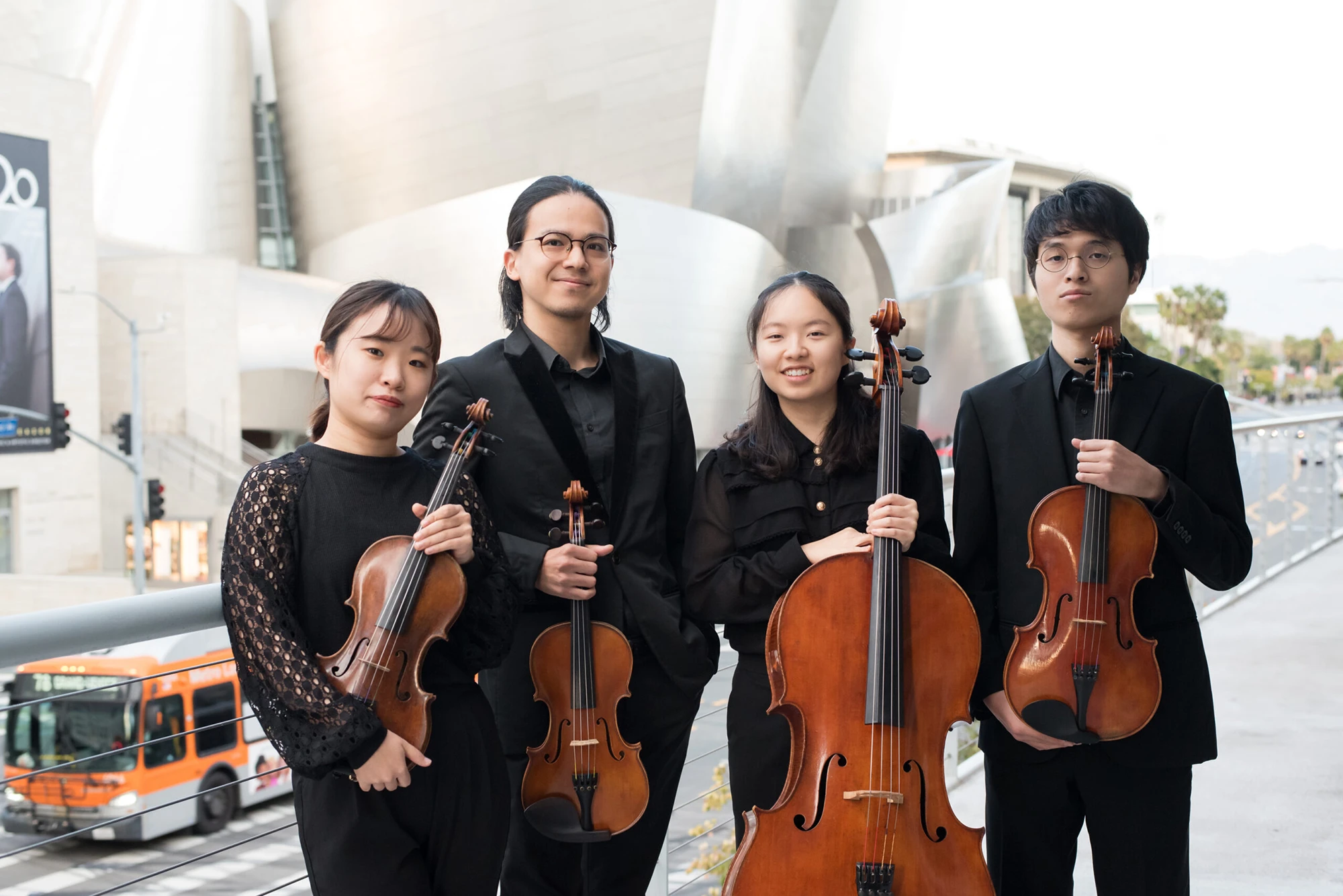 Photo of the four members of the Quartet Integra dressed in black and holding their instruments.