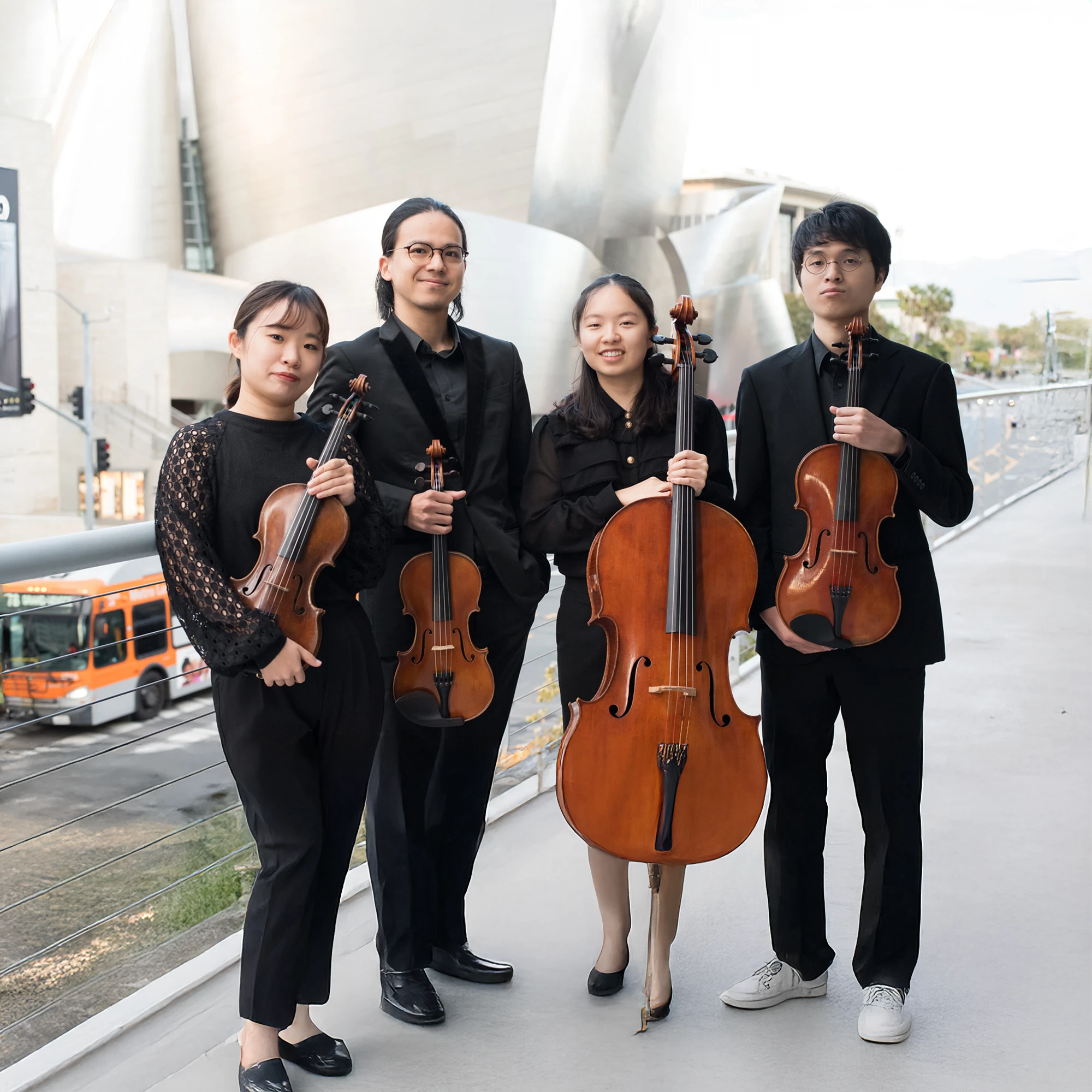 Photo of the four members of the Quartet Integra dressed in black and holding their instruments.