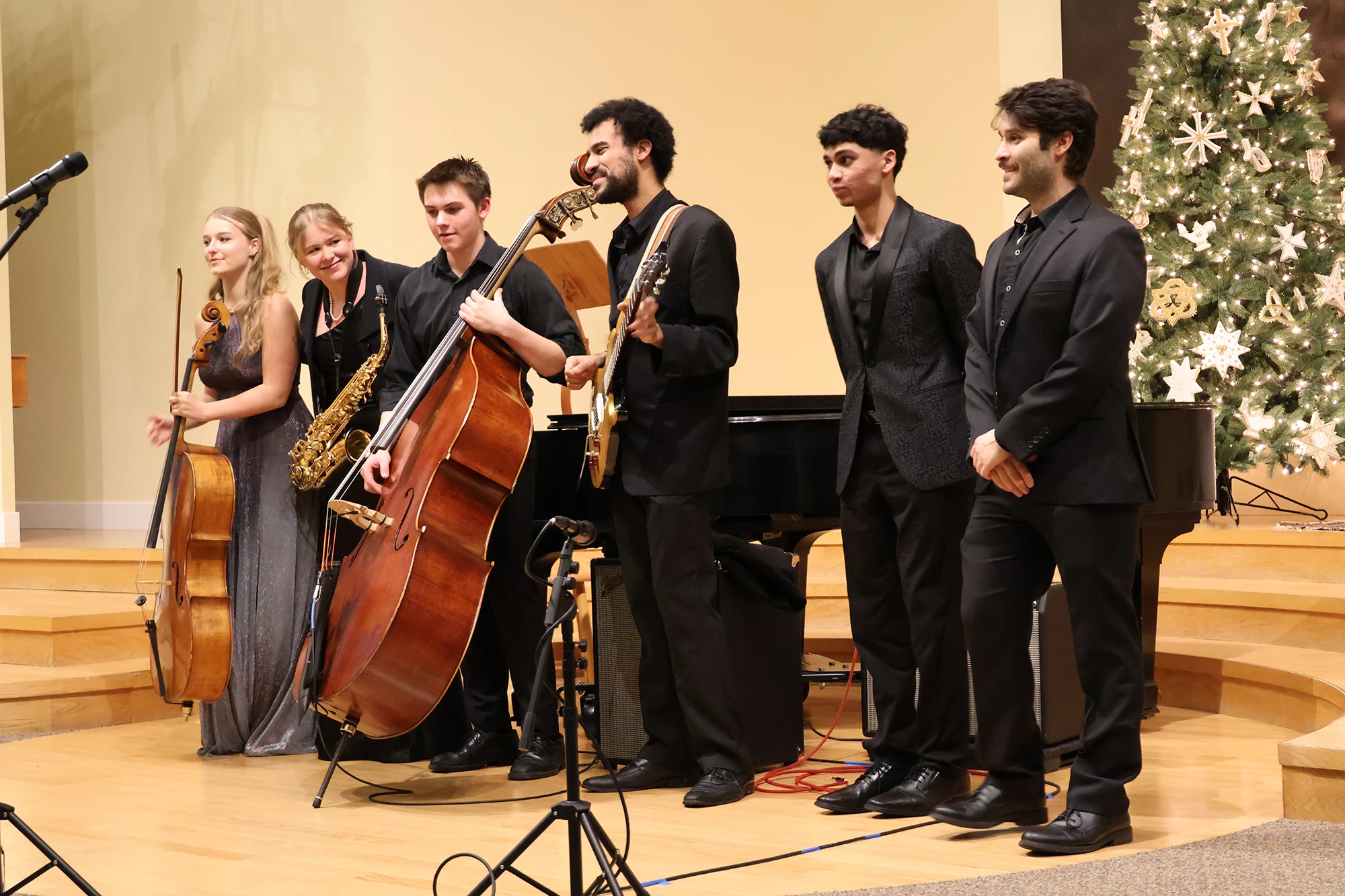 Photo of a group of young musicians, receiving applause at the end of a concert.