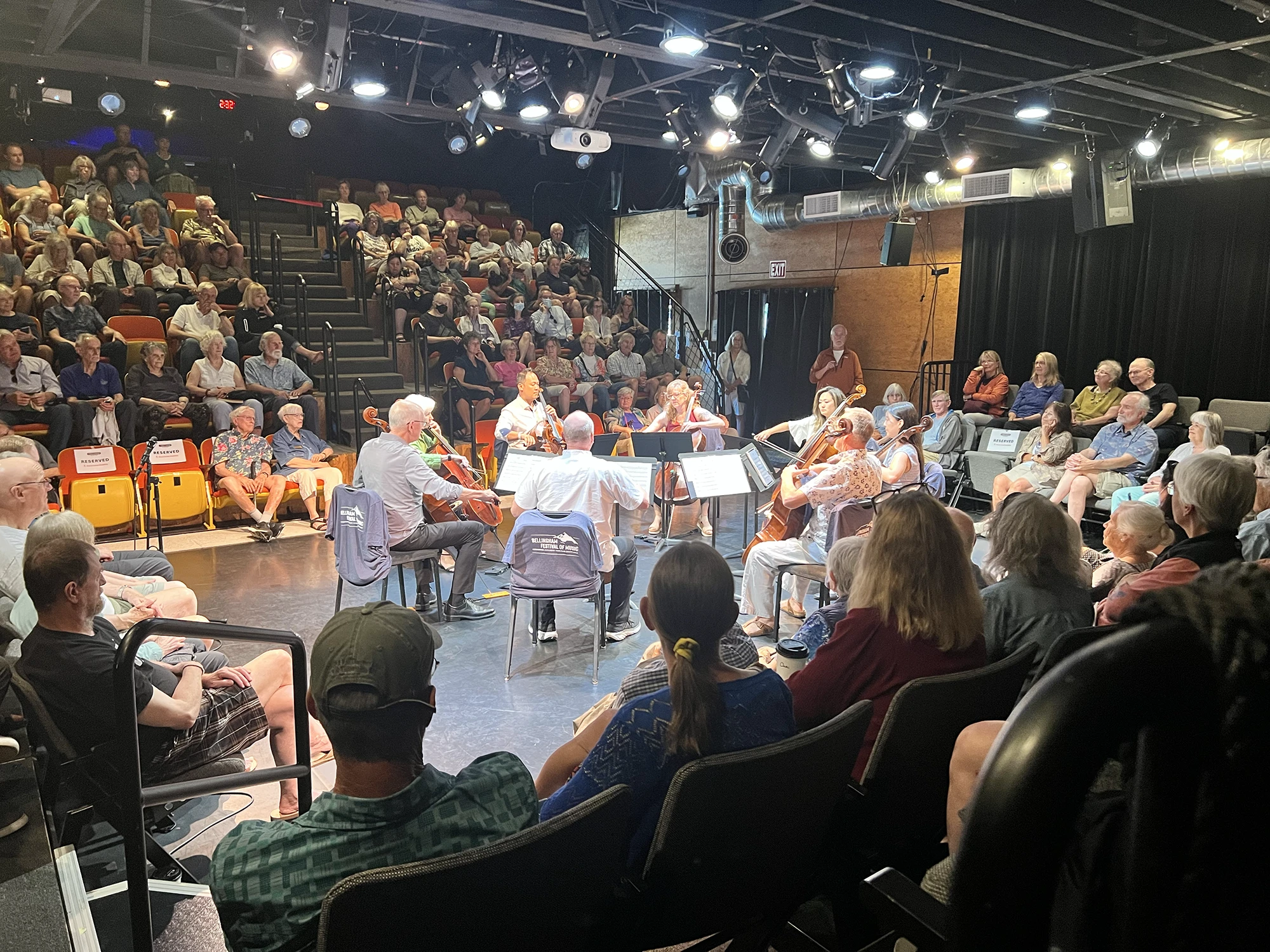 Community concert with string musicians performing a free chamber music concert for a seated audience in a small theater. Live music, free events, community arts, chamber ensemble performance, Bellingham festival of music.