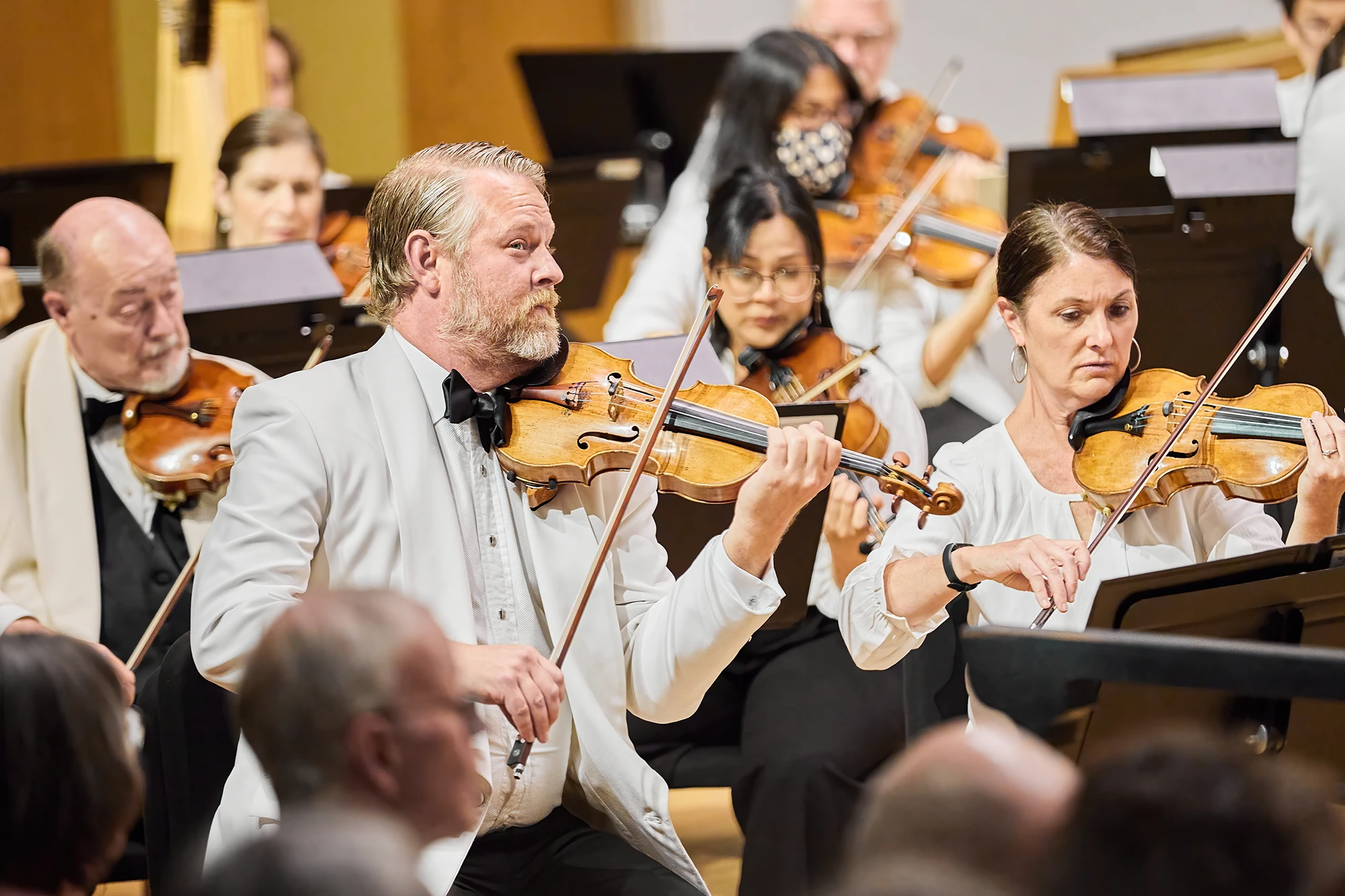 Violinist Justin Bruns performing a masterclass or concert with an orchestra. Classical music, violin, string section, live performance, Bellingham Festival of Music.