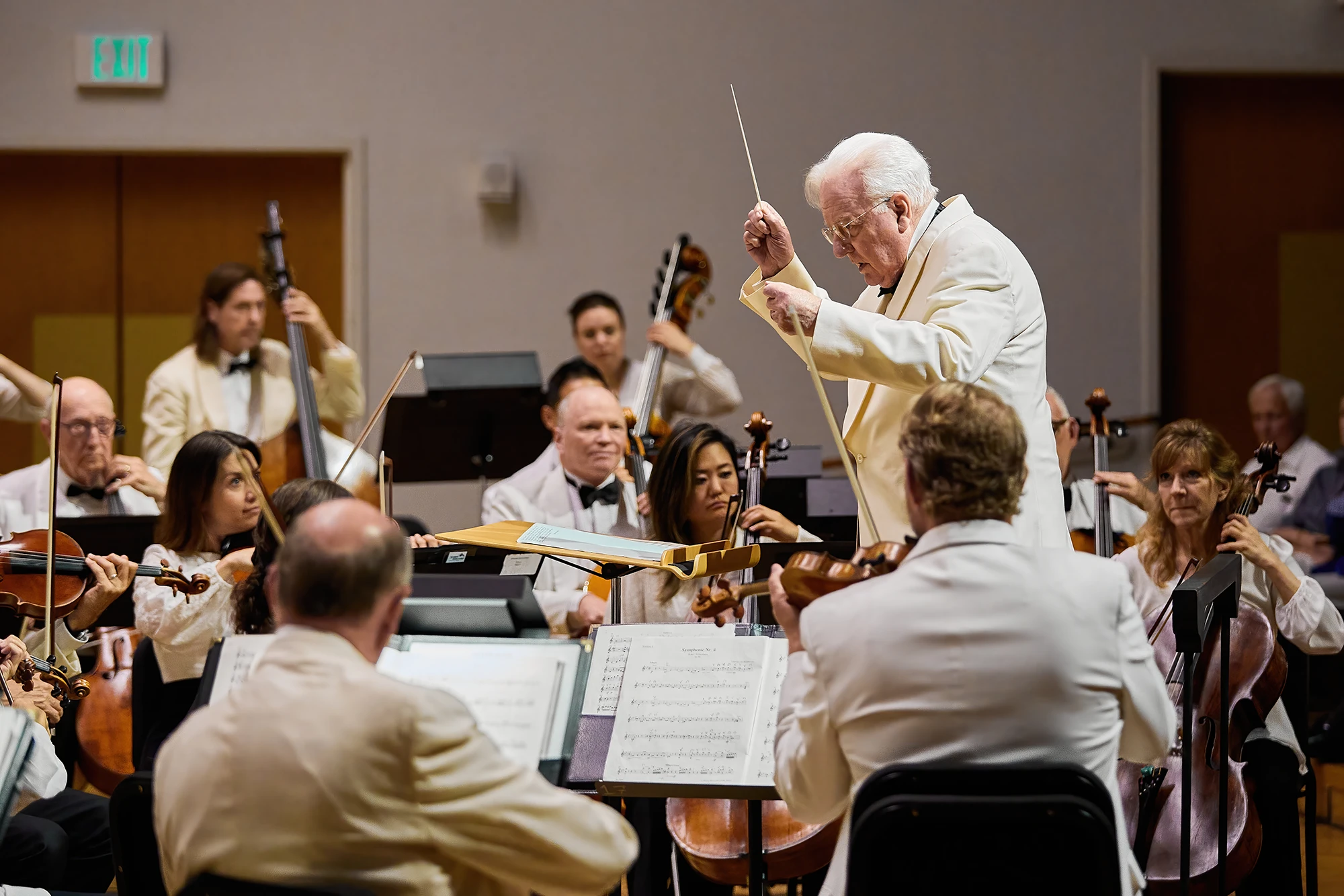Michael Palmer, Laureate Conductor, leading a full symphony orchestra during a performance. Classical music festival, live concert, orchestra conductor, Bellingham Festival of Music.