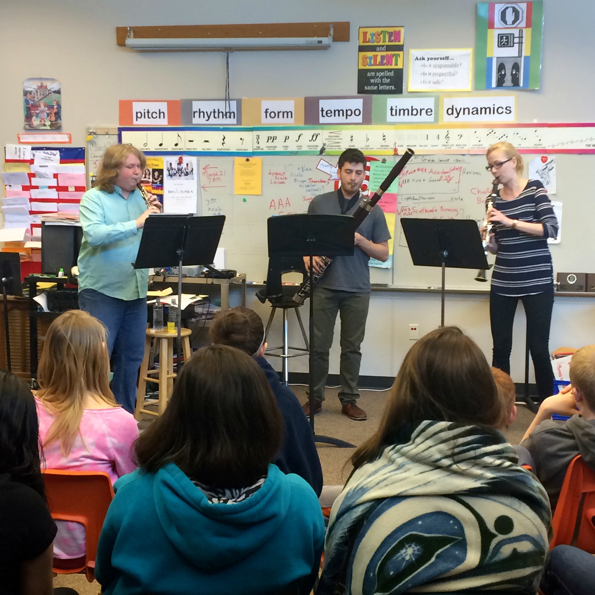 Musicians from the Olive Reed Trio performing an educational concert for a school classroom during a community music program.