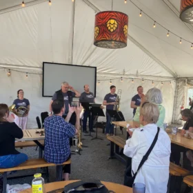 Bellingham Festival of Music brass quintet receiving a standing ovation from the audience inside the event tent at Stemma Brewing Co.