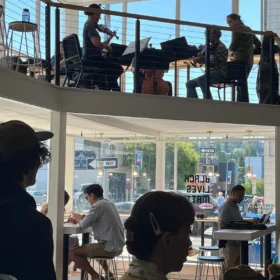 Classical musicians performing on the mezzanine balcony of Makeworth Market coffee shop during a community concert in Bellingham.