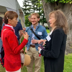Musician Harrison chatting with guests Holly Witte and a companion on the lawn during the Bellingham Festival of Music opening party.