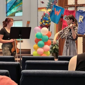 Violinist Tessa Lark leading a classical music masterclass with a student inside a church sanctuary in Bellingham.