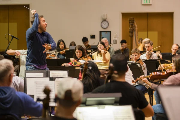 Marcelo Lehninger dynamically guiding the string section of the Bellingham Festival Orchestra during rehearsal.